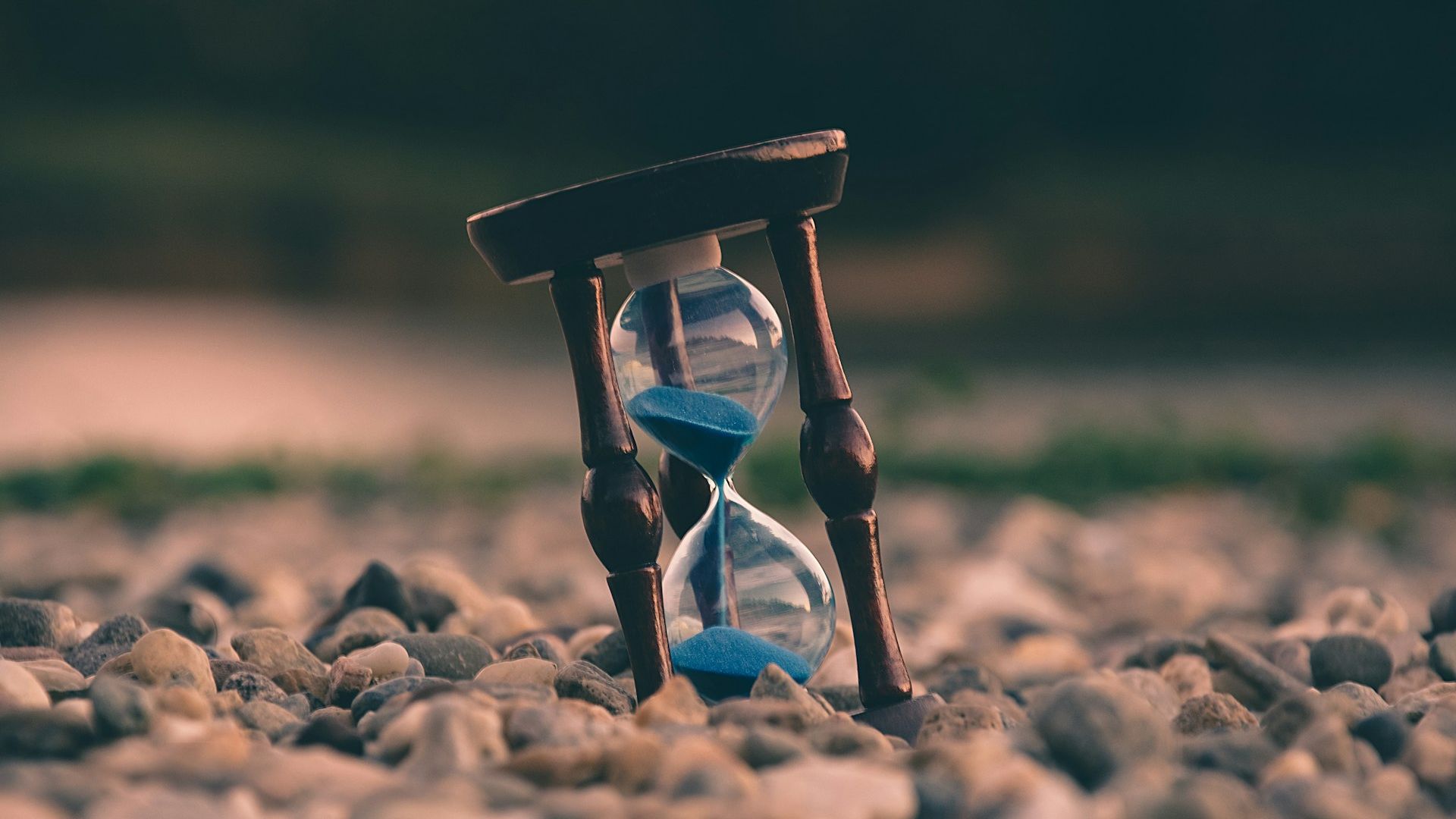 Sand timer propped up on a rocky beach