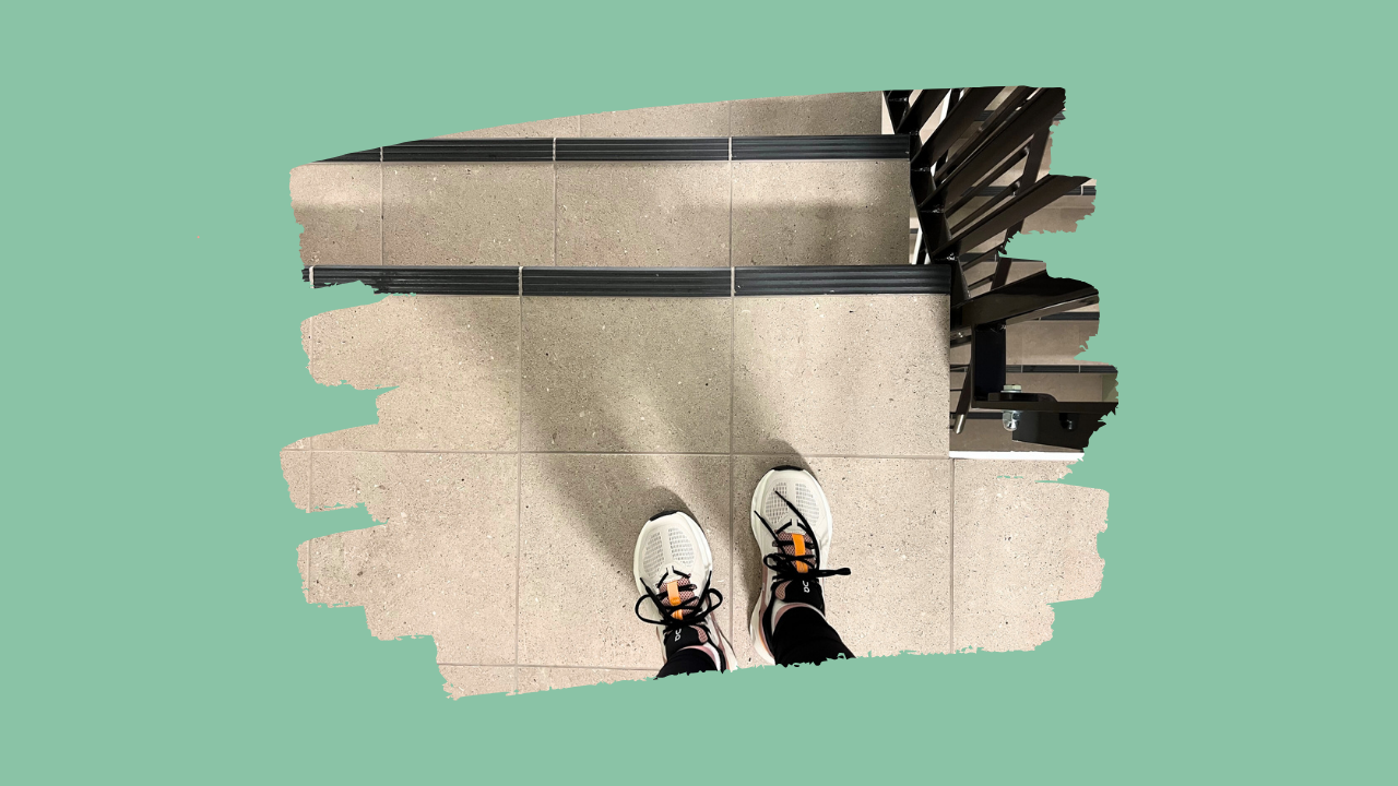 Pasient med FND stående på toppen av trapp klar for gåtrening