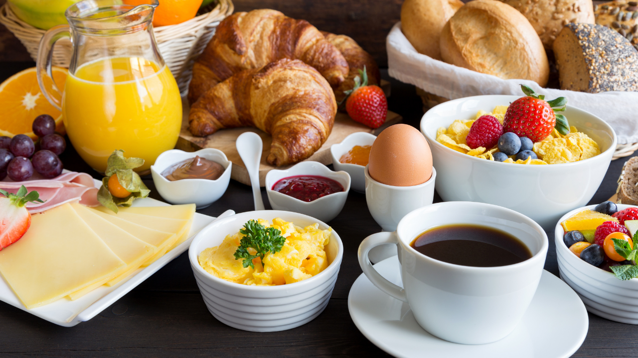 A large, colorful variety of breakfast foods in white dishes on a table