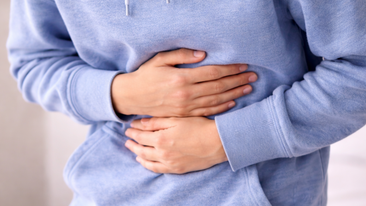 Child holding their stomach to represent ongoing gut pain or abdominal discomfort