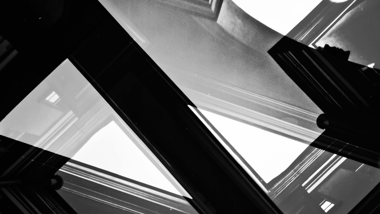 Abstract black-and-white architectural lines intersecting at sharp angles, creating a sense of structure, tension, and alignment
