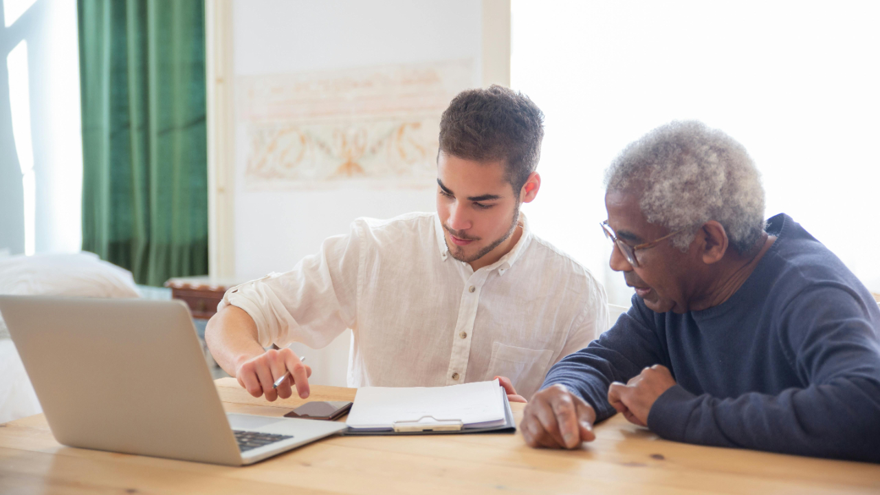 Two professionals in discussion over a laptop, representing effective networking