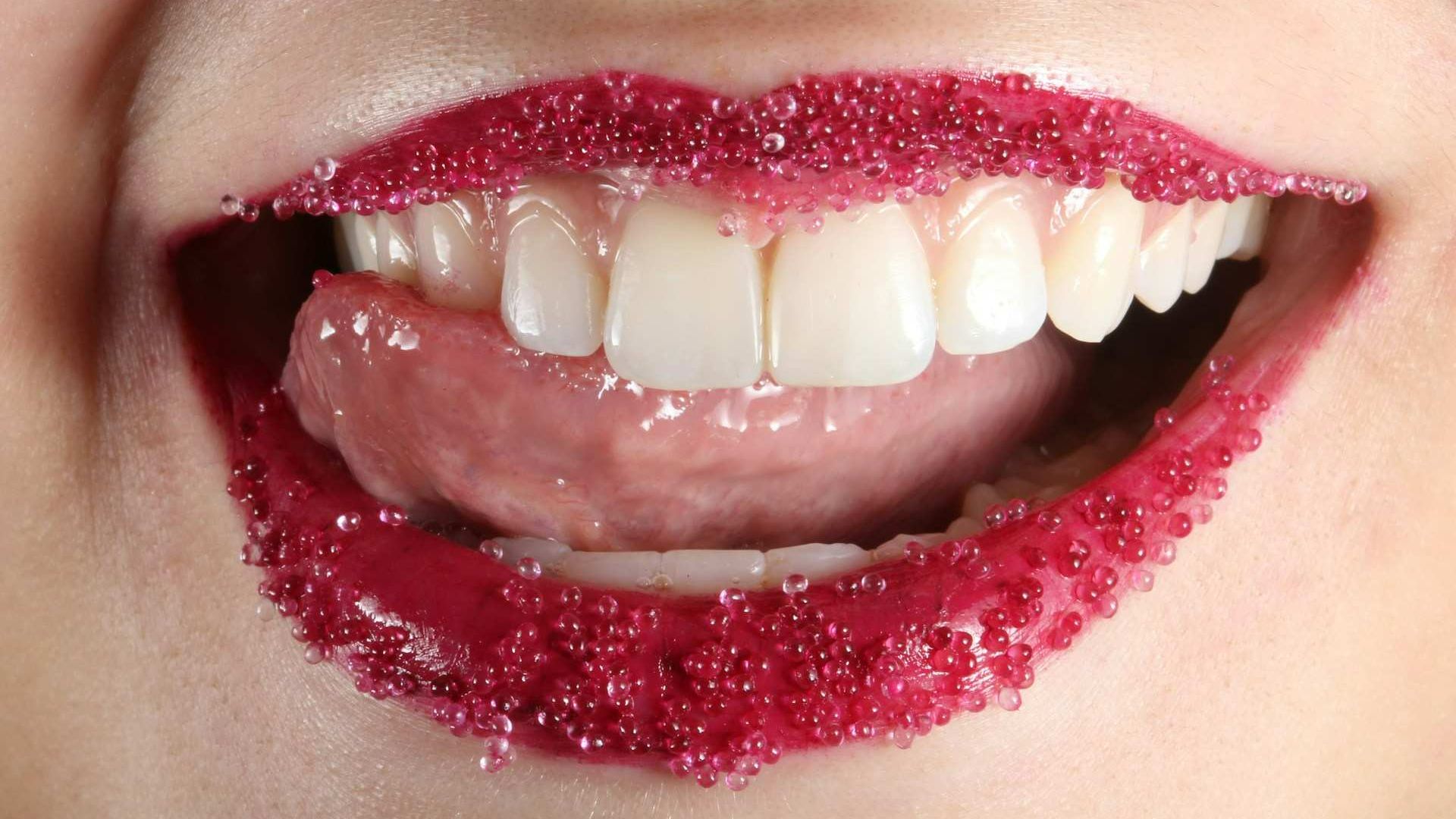 Close-up of bleeding gums with visible inflammation around healthy white teeth showing oral microbiome imbalance.