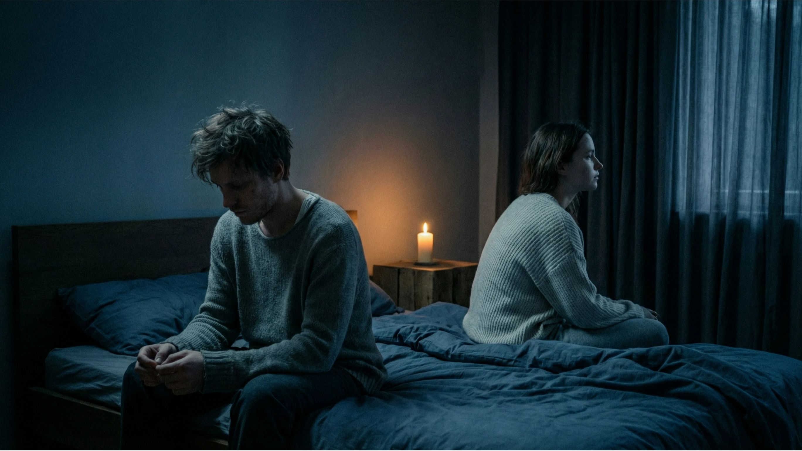Couple sitting apart on a bed with a single candle between them, illustrating hormone imbalance and sex drive decline affecting intimacy and emotional connection.