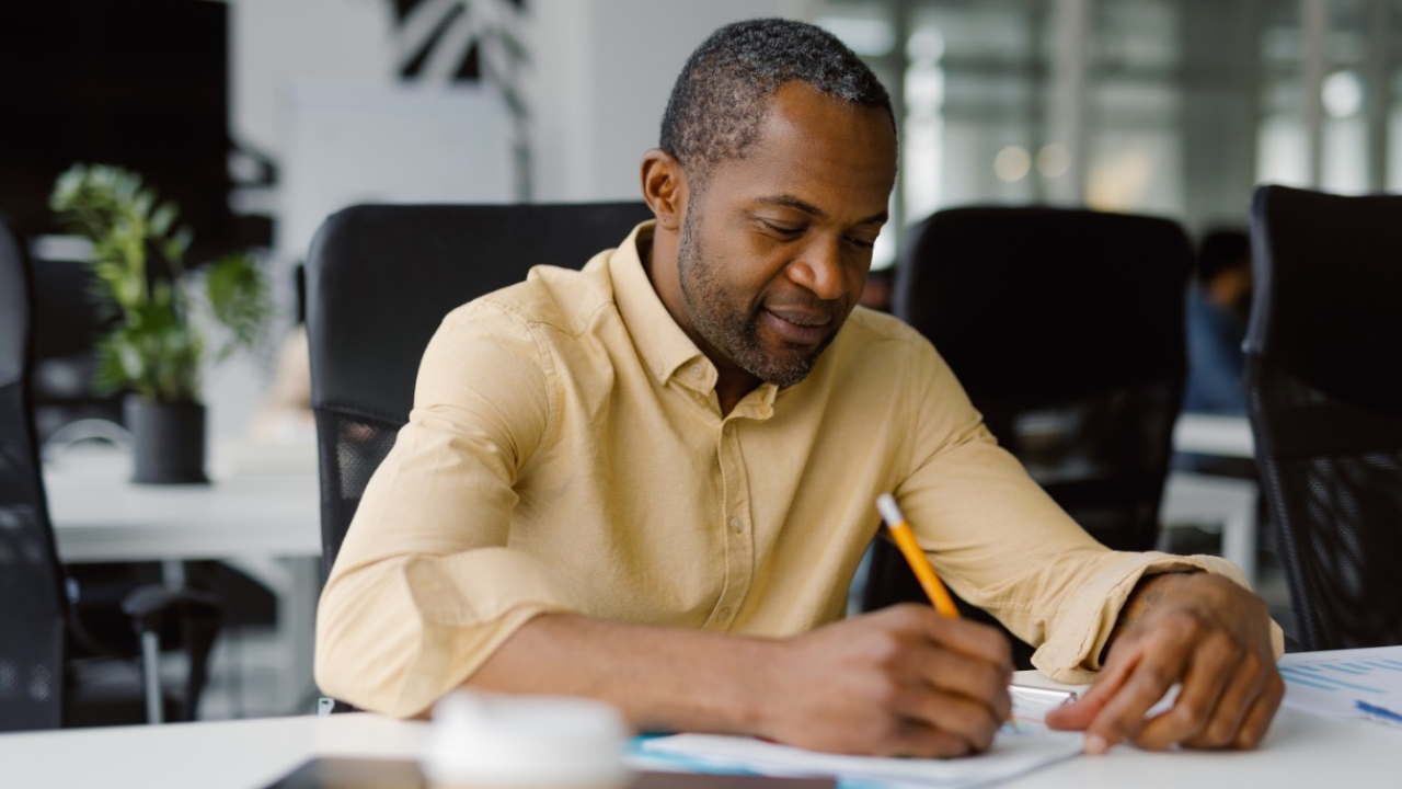 Coach engaging in reflective practice by writing notes after a session