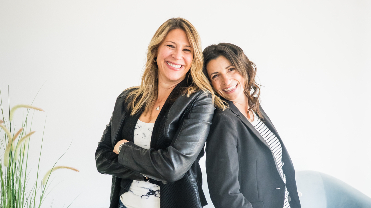 Bride and groom smiling while planning their wedding together using a laptop and color palette samples