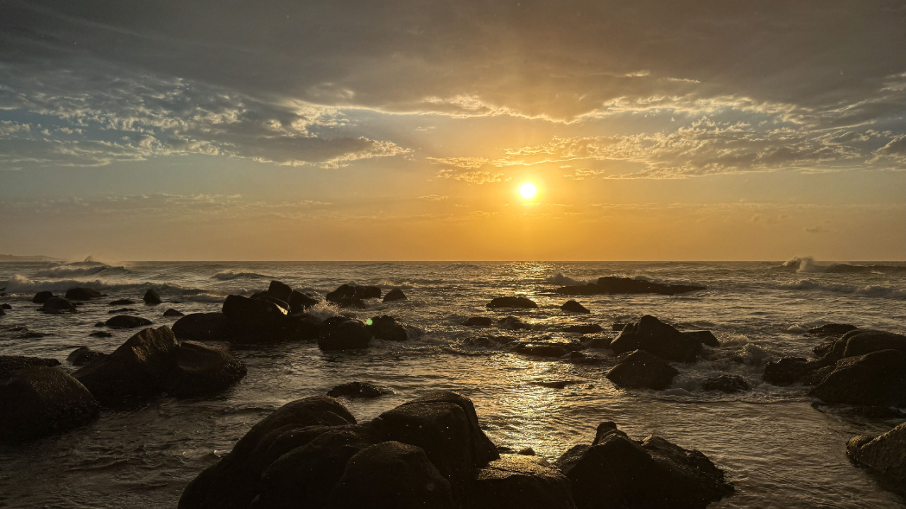 Sonnenuntergang über dem Meer mit Felsen im Vordergrund symbolisiert Ruhe und Klarheit