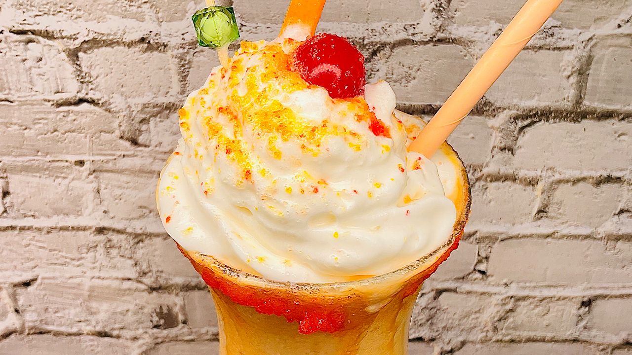 Orange Julius made with evaporated milk, frothy and creamy in a glass.
