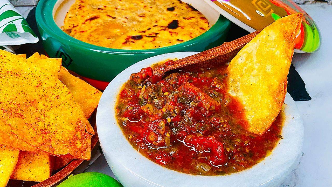 Garden-fresh chunky salsa with tomato, avocado, and chili-lime rimmed glass.