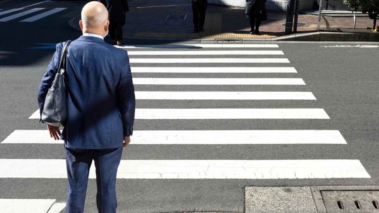 Leader standing consciously in a fast-moving world, choosing awareness over autopilot.