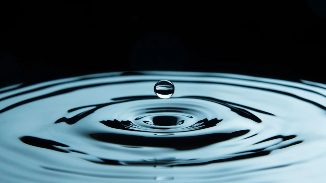 A high-contrast photo showing a ripple effect in dark water, symbolising the 'wake' a leader leaves behind.