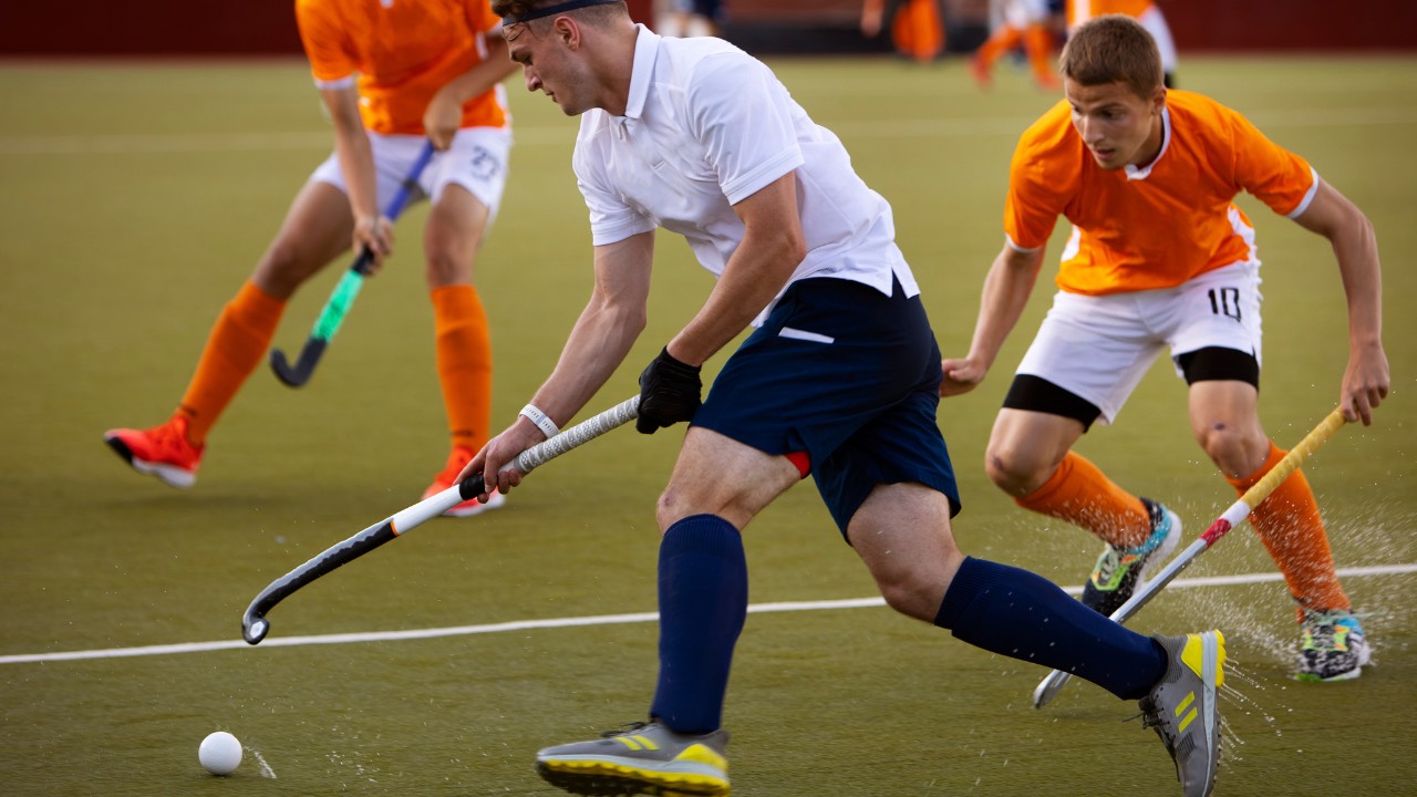 image of men playing hockey to demonstrate Why Coordination is the Secret to Team Performance