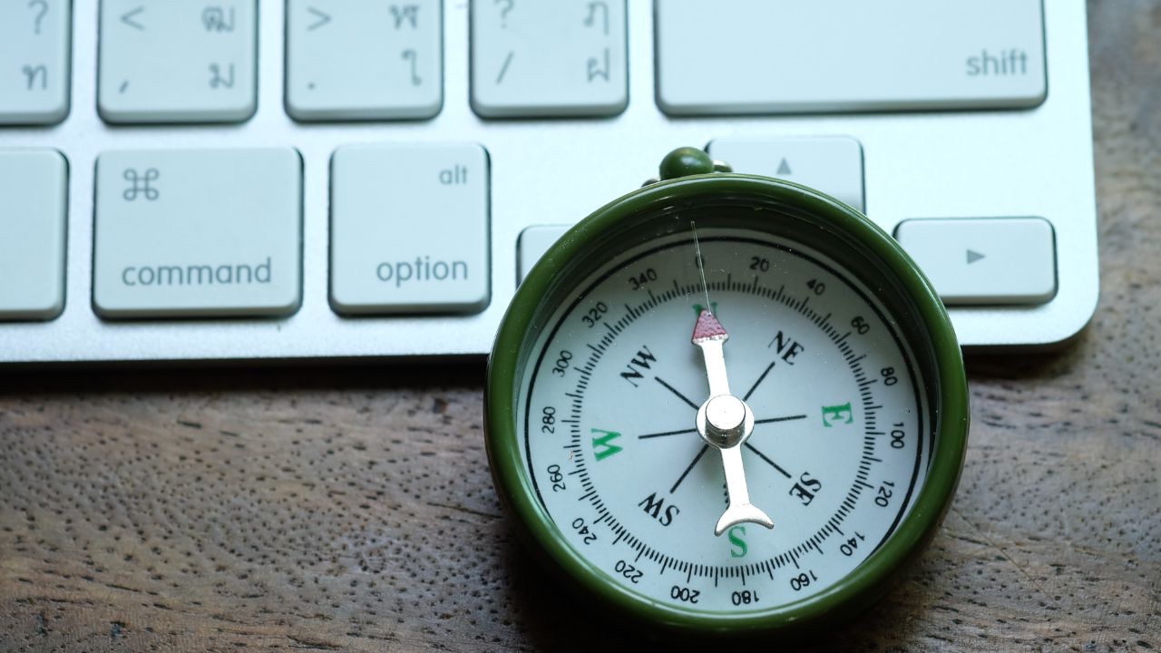 image of compass and keyboard to demonstrate Beyond 10 Year Strategies: Why Trust Is the Real Engine of Adaptability