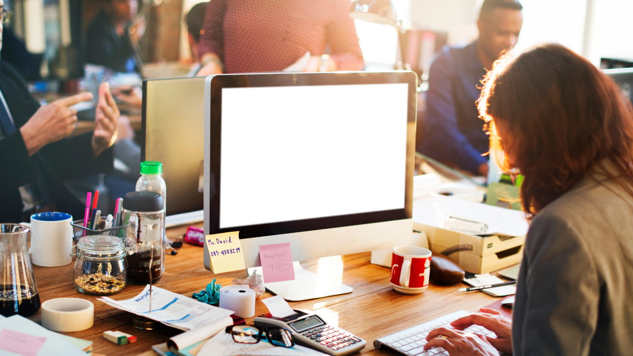A busy open-plan office where people are present but disconnected, each focused on their screen, symbolising emotional distance at work.