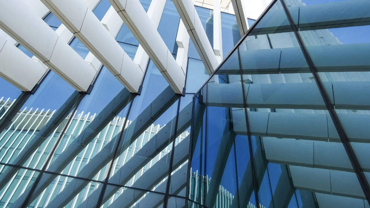 A modern building facade with intersecting beams and reflective glass panels.
