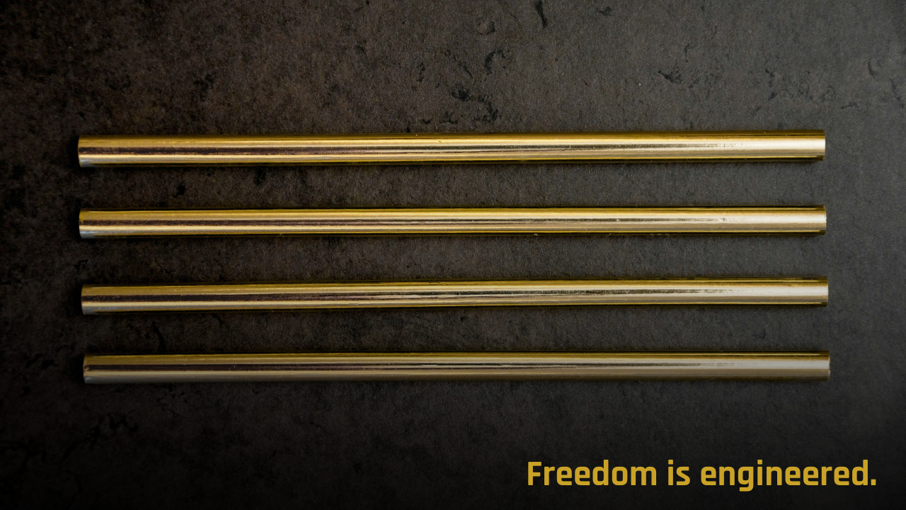 Four gold metal rods aligned in parallel on a dark background, symbolizing order, clarity, and structured leadership systems.