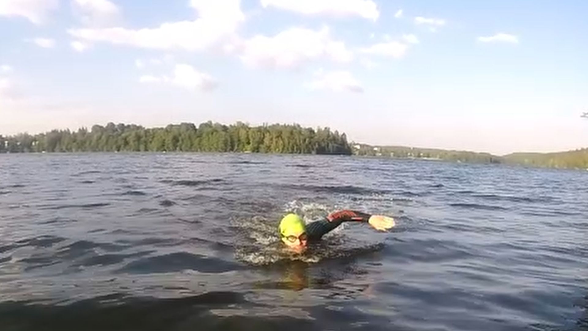 Uimari suunnistamassa avovesiuinnissa nostamalla katsetta eteen vapaauinnin hengityksen yhteydessä