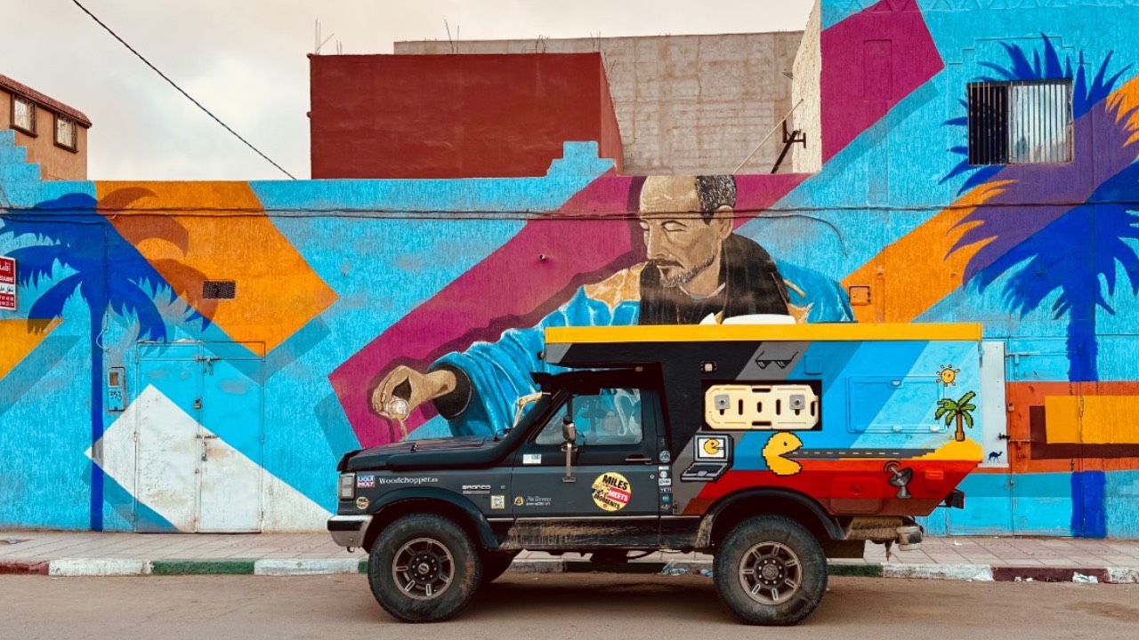 Ford Bronco Campervan auf Weltreise vor Graffiti Wand als Teil von MilesMeetsMoments