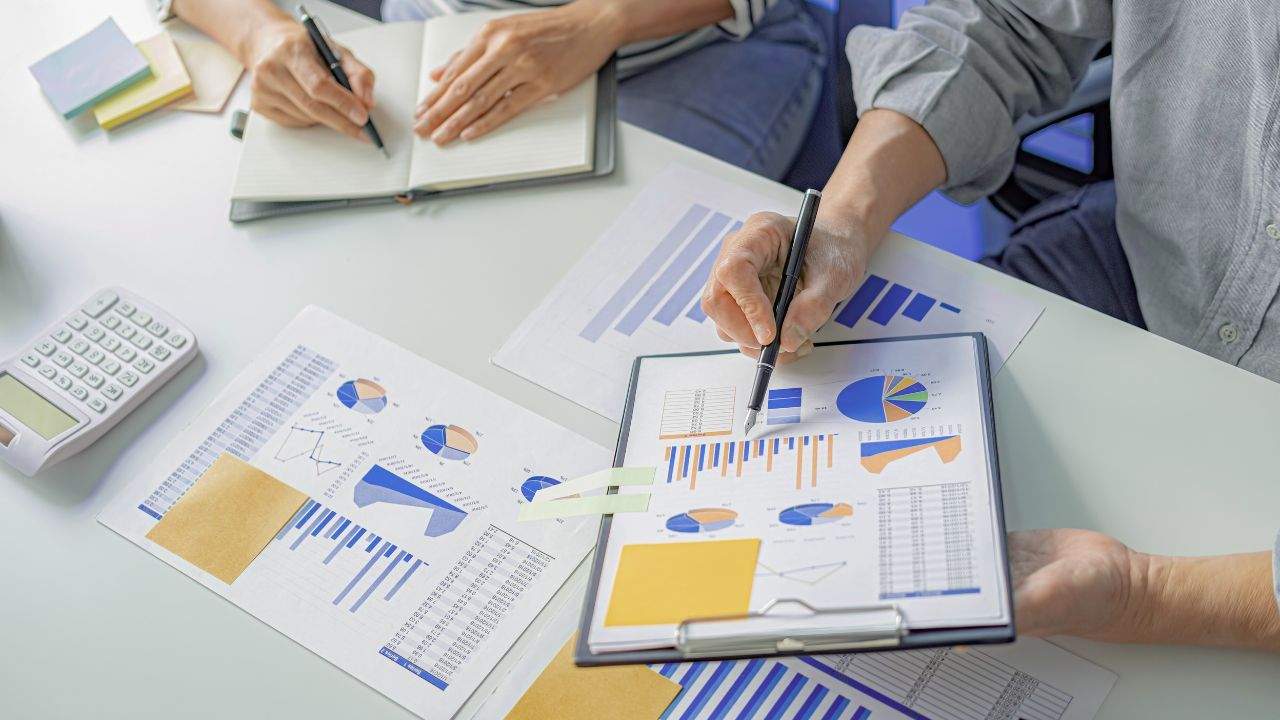 Two professionals analysing ESG‑framework charts and graphs to drive strategic sustainability‑reporting decisions.