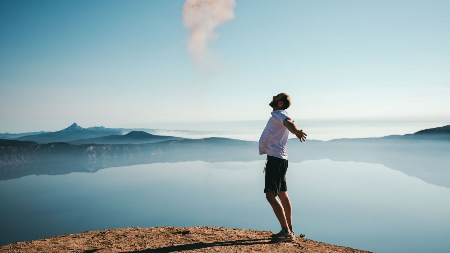 uomo felice da solo vicino a un lago in montagna