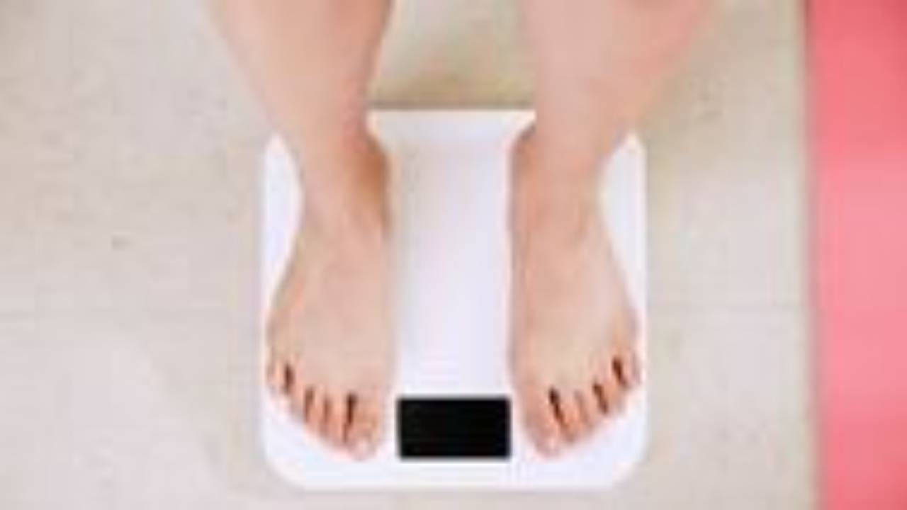 uomo che si pesa su una bilancia