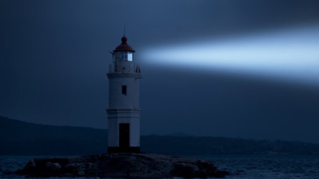 Lighthouse standing steady at dusk symbolizing calm leadership and secure attachment in parenting. 