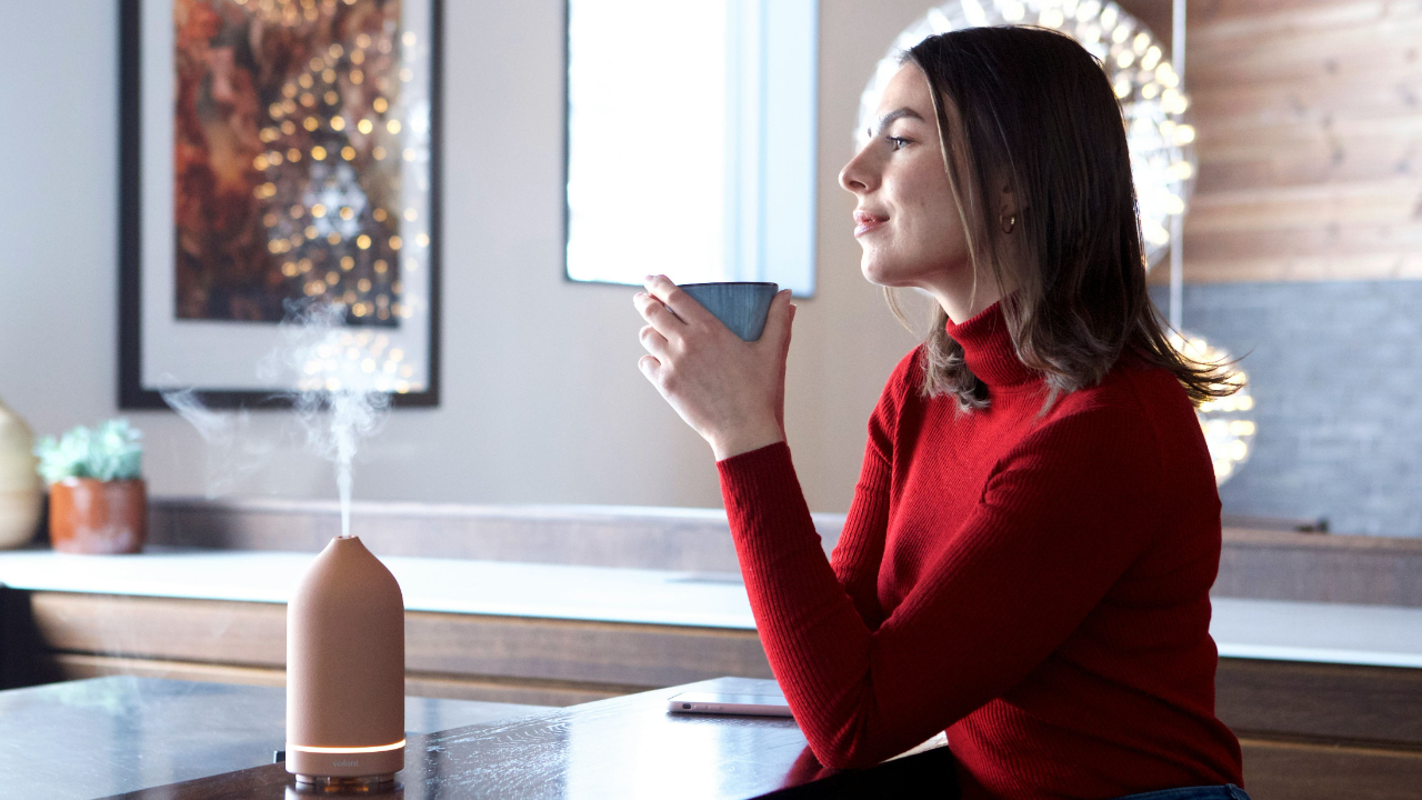 Woman sitting calmly with a cup of coffee, taking a quiet moment to reflect and slow down after financial overwhelm