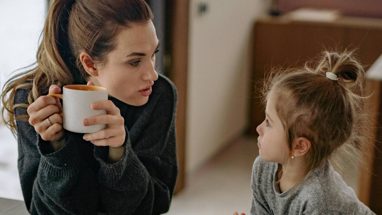 Mother and daughter sharing a thoughtful conversation at home, modeling healthy and judgment-free money lessons.