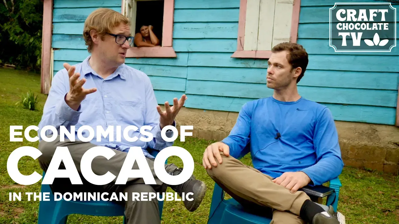 Image of two men talking with tex reading "Economics Of Cacao In The Dominican Republic". 