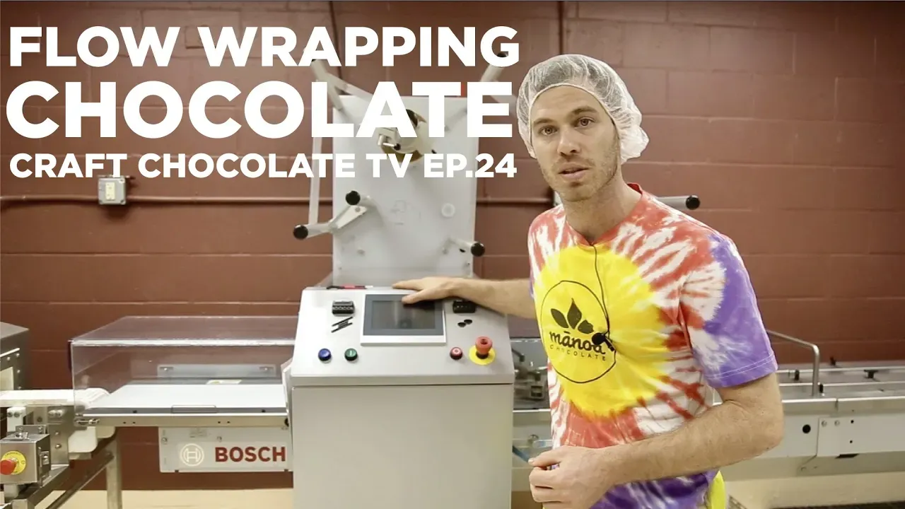 Man standing next to flow wrapping machine with text reading "Flow Wrapping Chocolate"