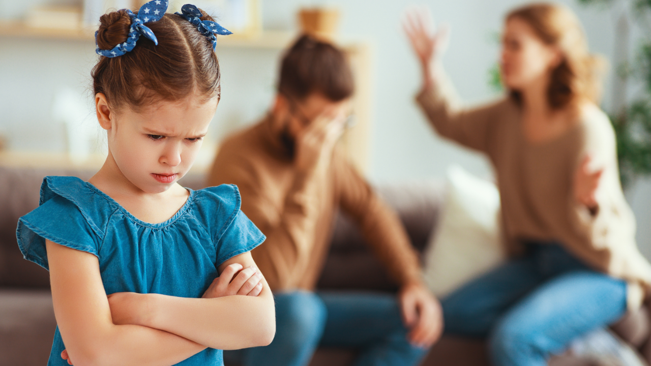 Niño triste observando a sus padres pelear en casa, concepto de consecuencias de quedarse juntos por los hijos.