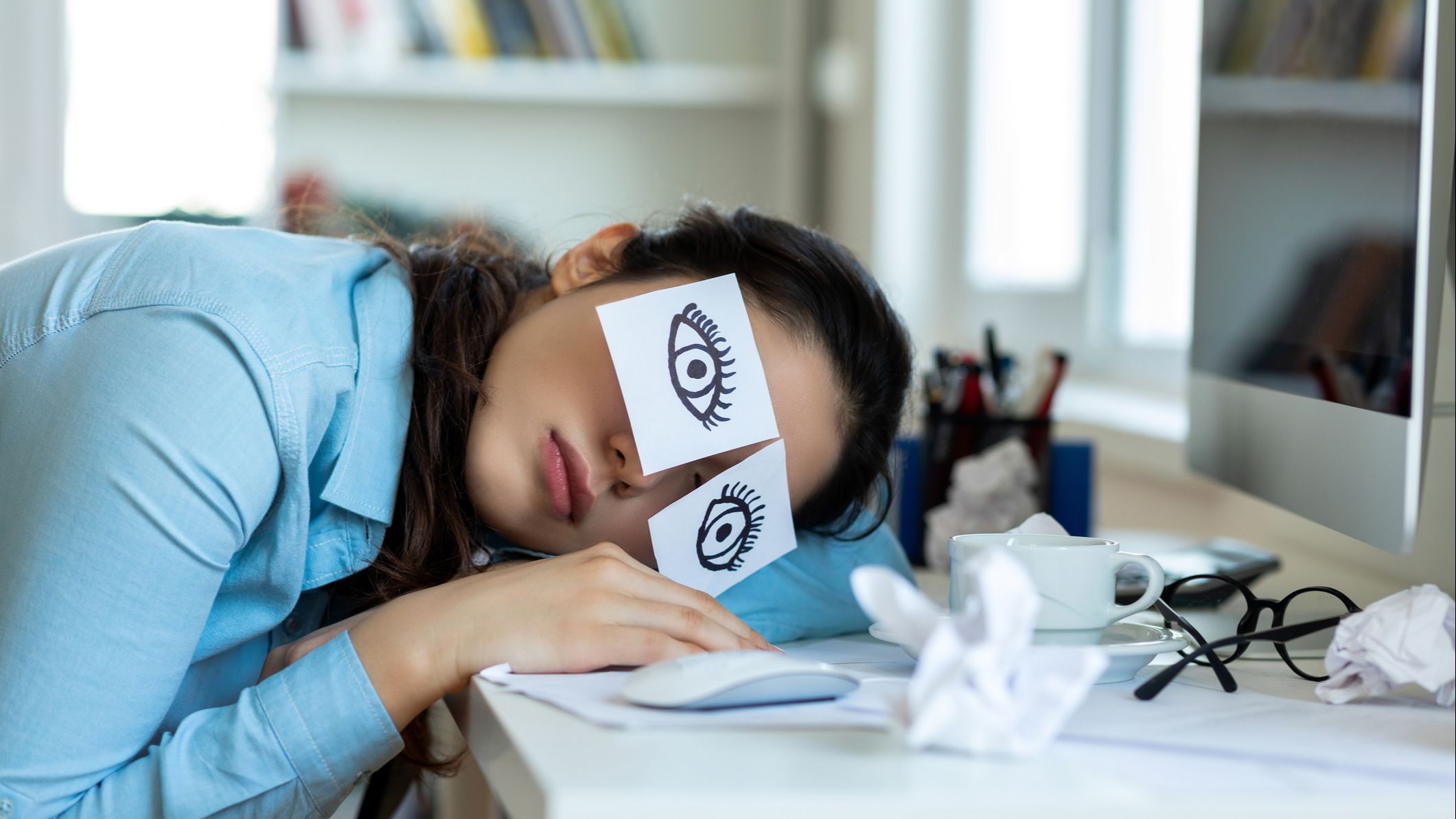 young professional bored in role and asleep at desk