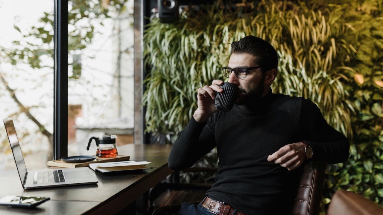 Person looking out window with a warm drink, reflecting at the end of the year and creating mental clarity