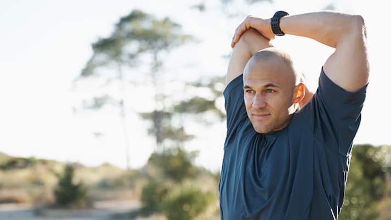 Person stretching in calm morning light to improve recovery, mobility, and energy