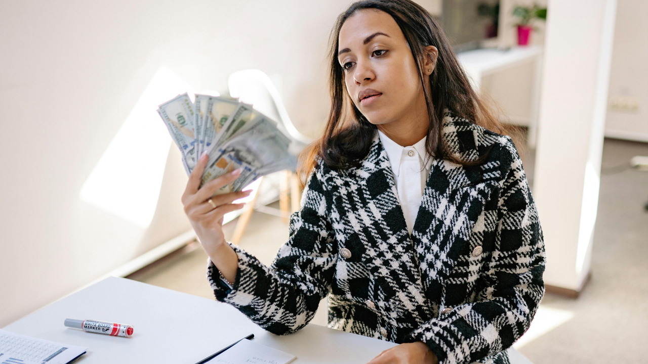 Femme pratiquant son rituel de suivi financier avec calme et intention dans son salon.