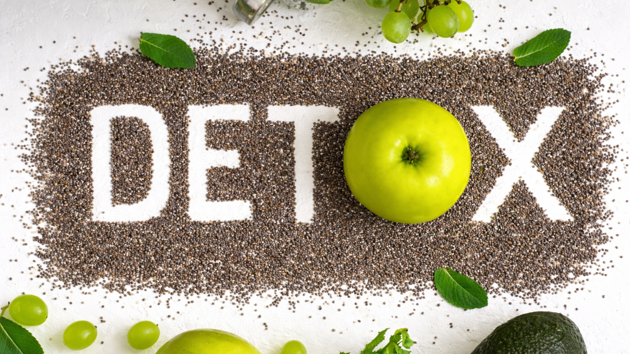 Detox concept with the word DETOX formed from chia seeds, green apple as the letter O, surrounded by mint leaves, grapes, and avocado on a white background