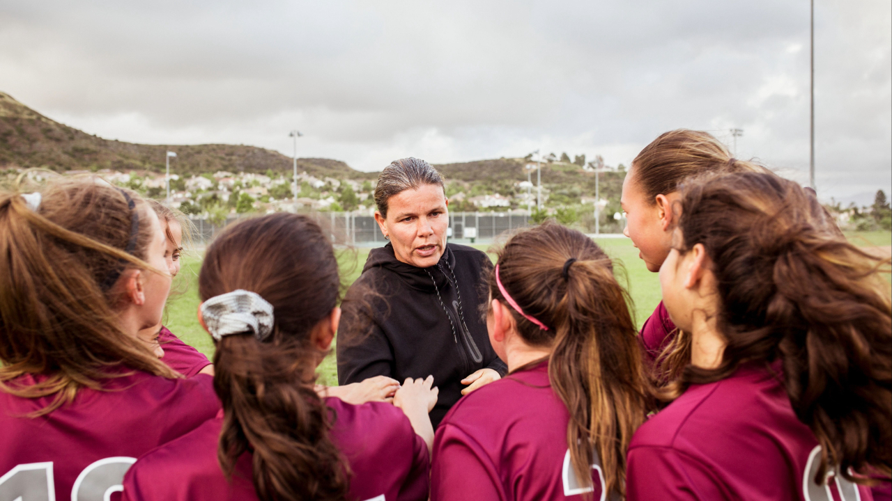 Coach of college team talking with players about High Performing Team Development 