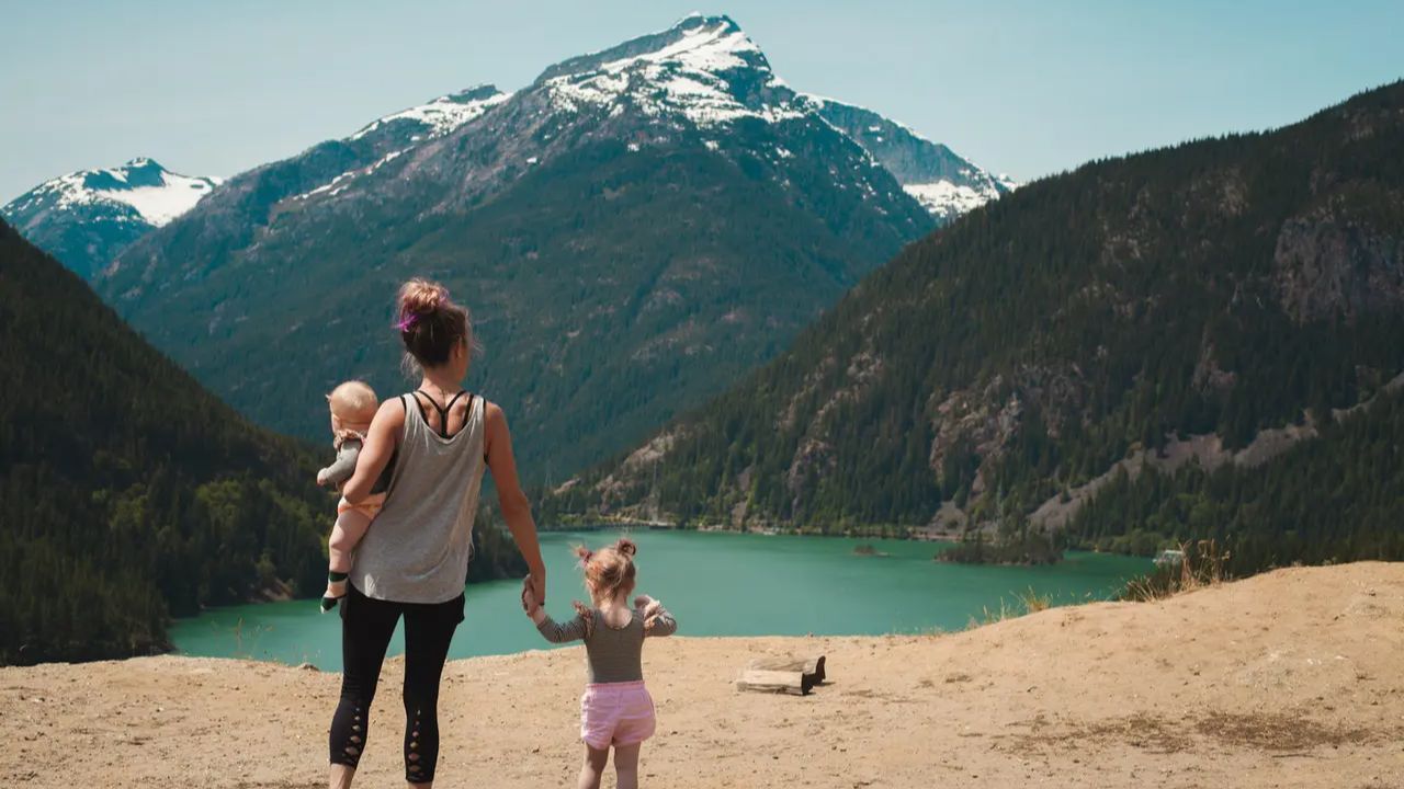 mother-with-two-children-overlooking-mountain-lake