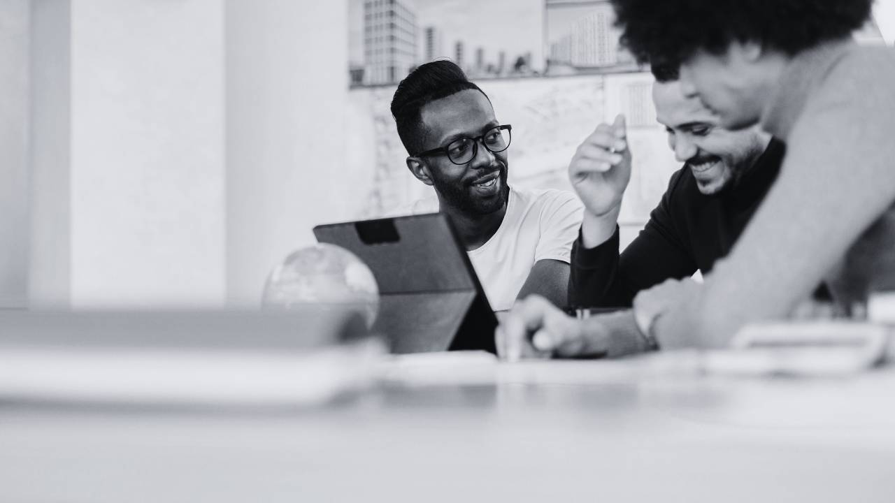 Workers sitting and working together, looking joyful, Empathy alongside capitalism