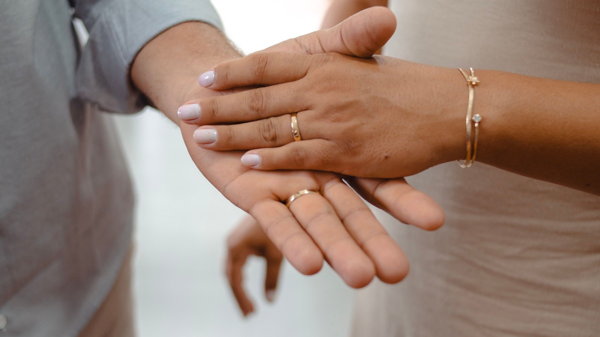 Close-up of two people gently holding hands, illustrating affection and mutual respect