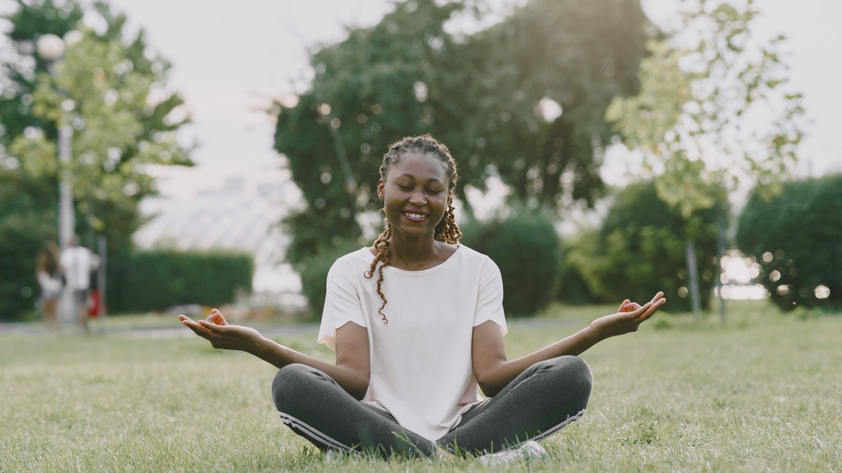 Woman sitting peacefully outdoors, reflecting on a healthier relationship with money