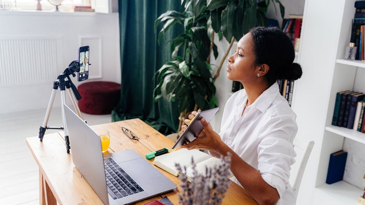 a woman speaking in front of a mobile phone as if live streaming