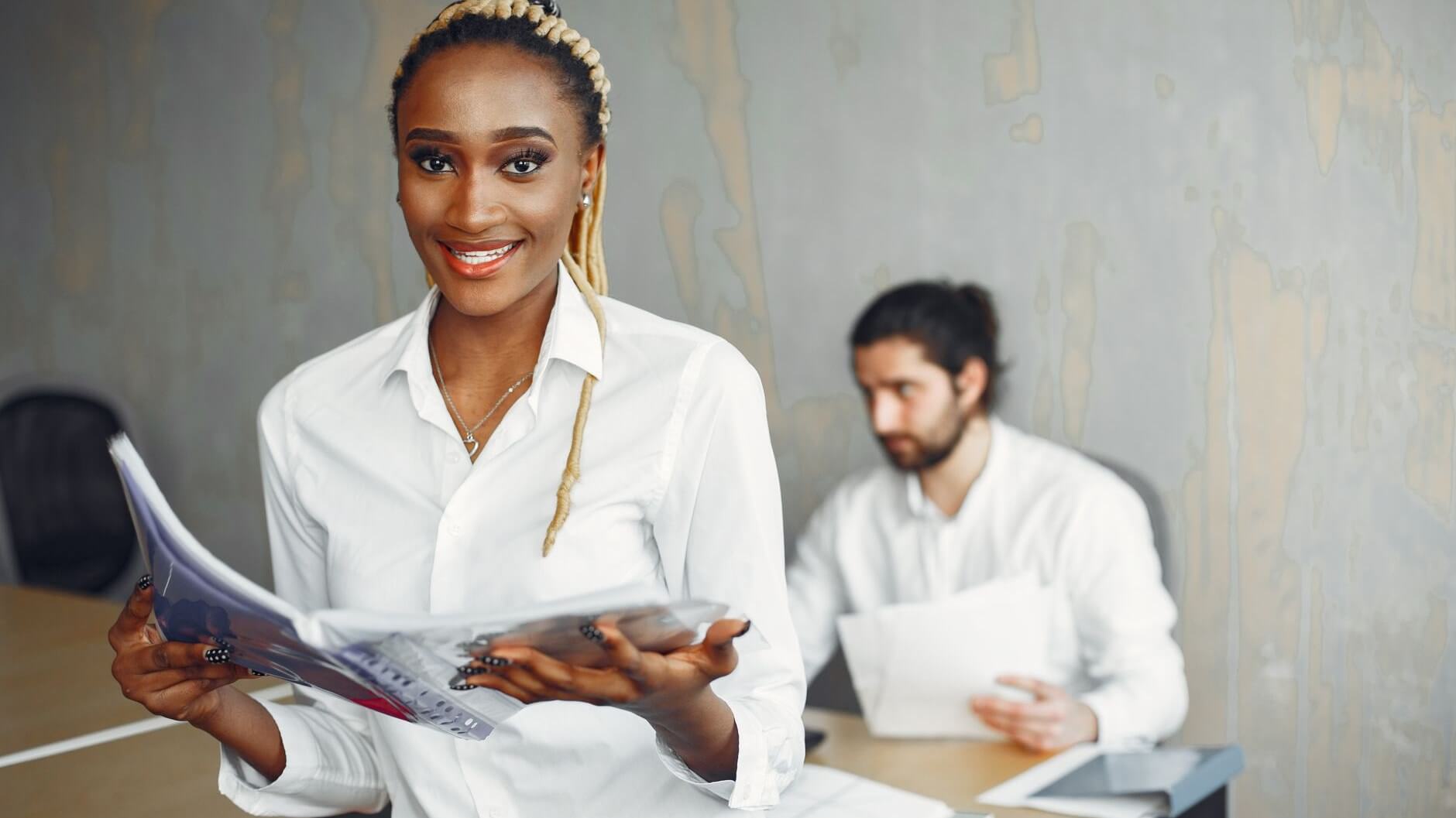 a woman holding a folder looking at the camera
