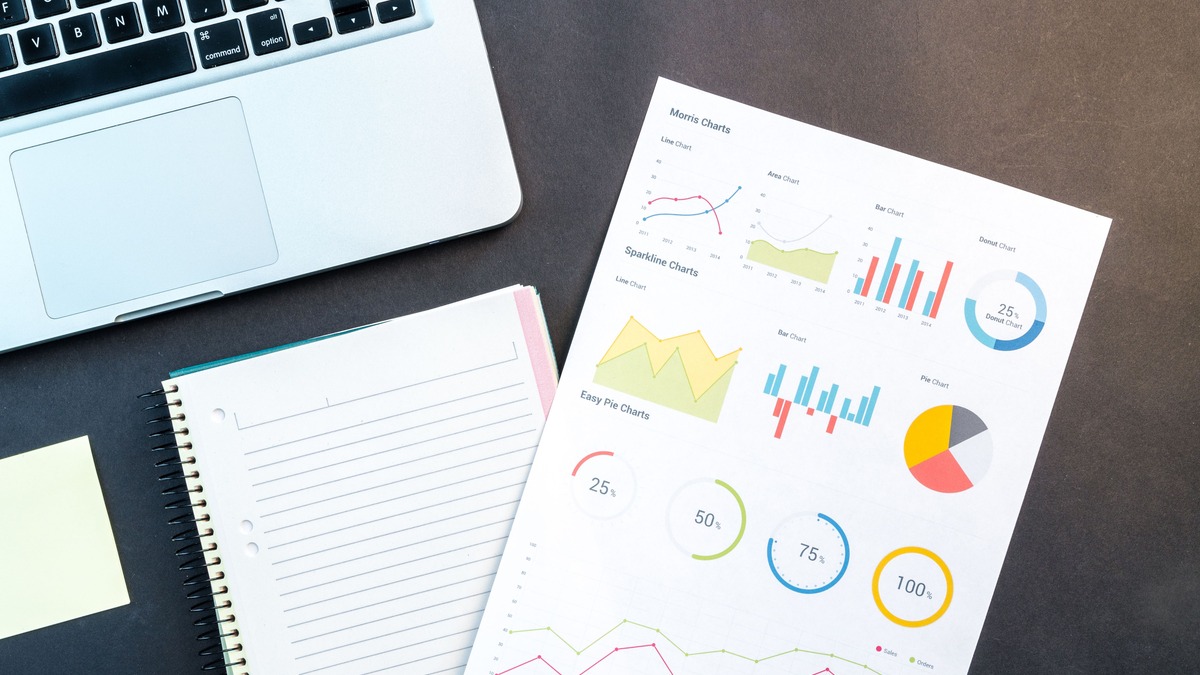 Notebook and financial charts on a desk, representing the return on investment of a money mindset course