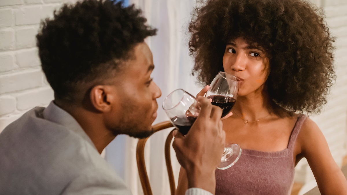 Couple seated together with wine glasses, illustrating the need to reconnect in a long-term relationship