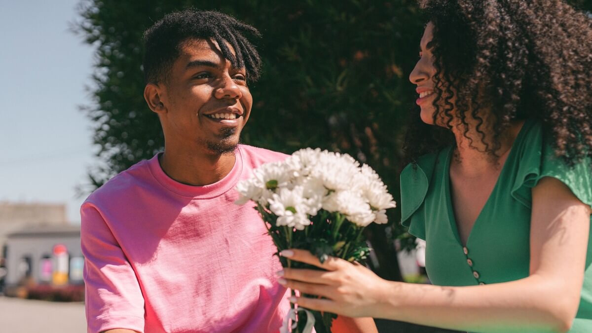 a woman holding a bouquet of flower and a man beside her