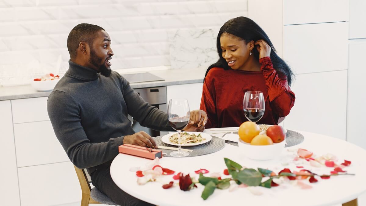 a man and a woman holding hands while eating