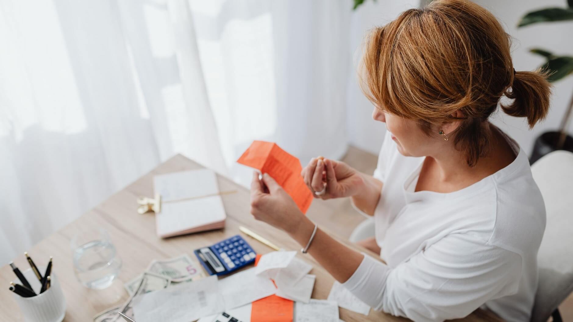 a woman looking at bills and receipts