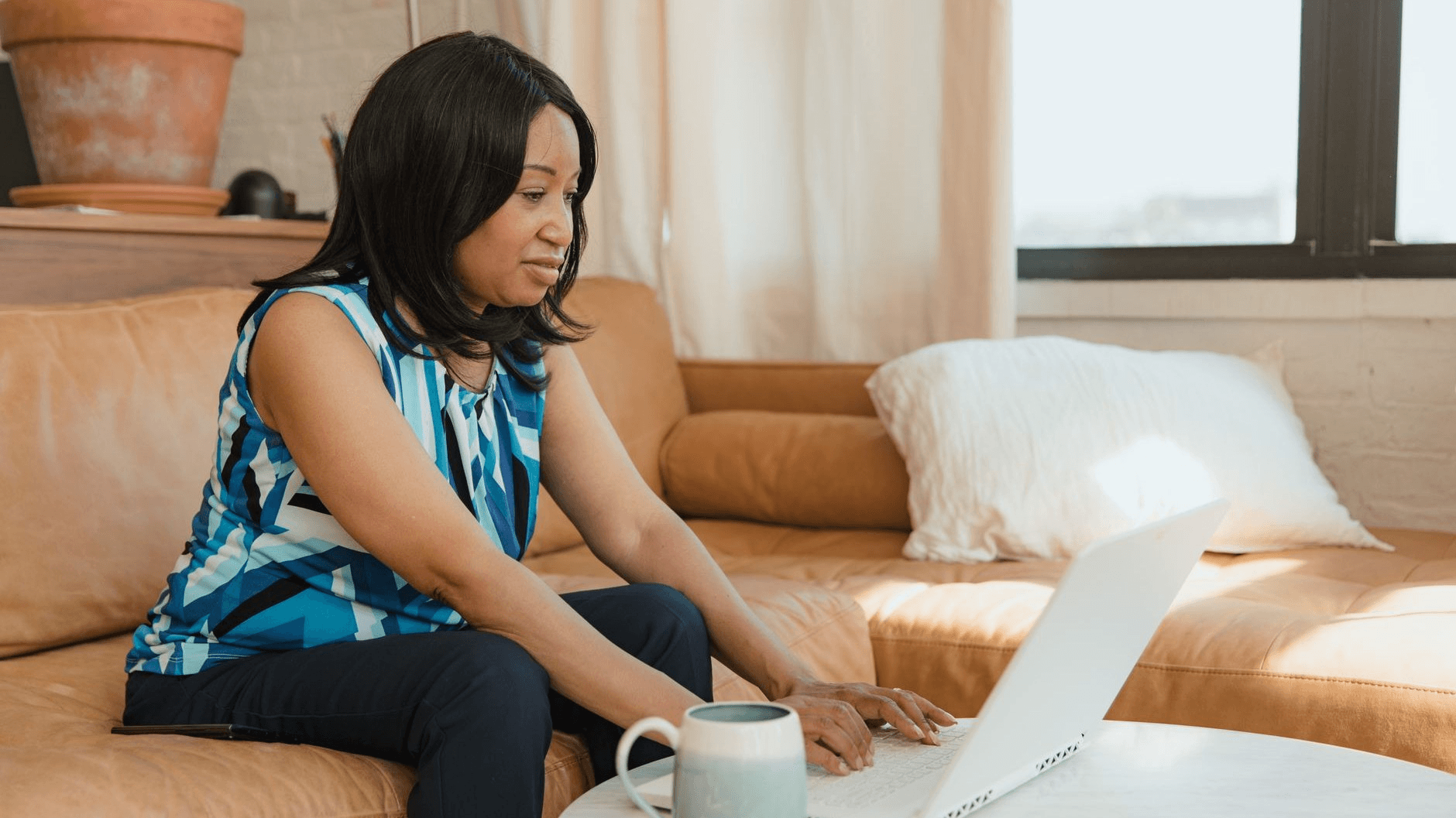 a woman working on his laptop on the couch