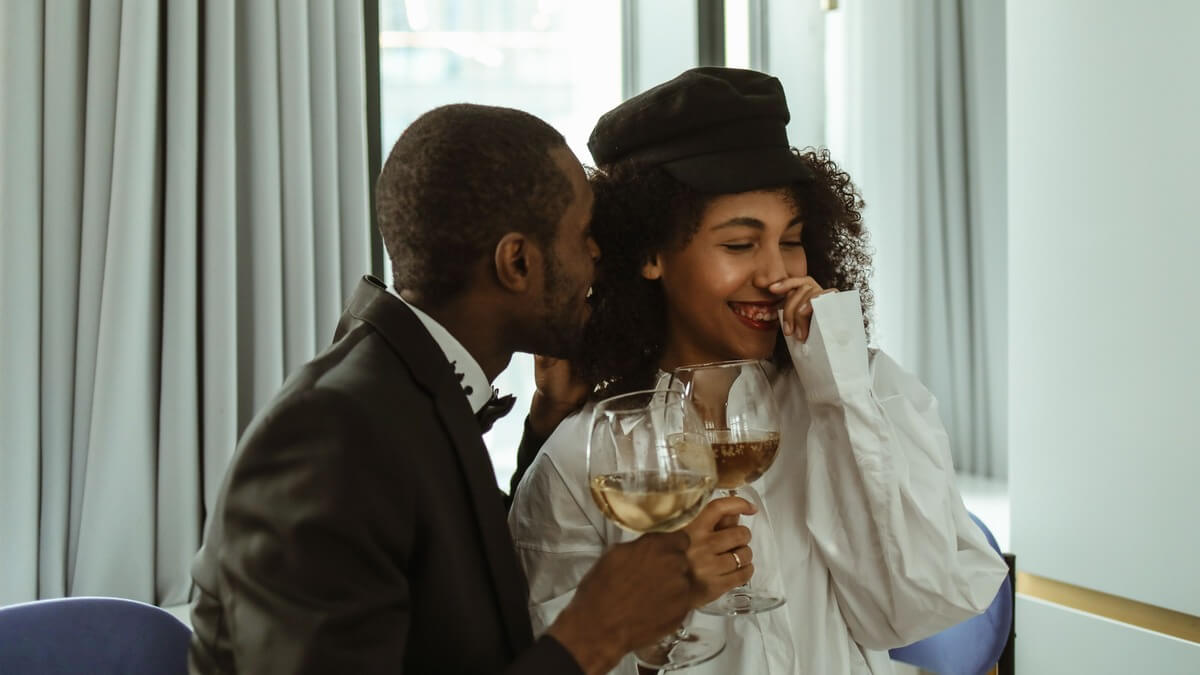 a man and woman holding champagne glasses and laughing